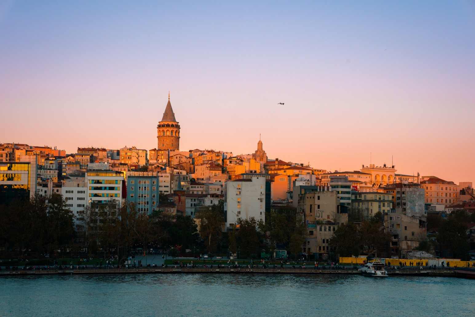 Galata Tower rising above the Istanbul skyline at sunset, viewed across the water