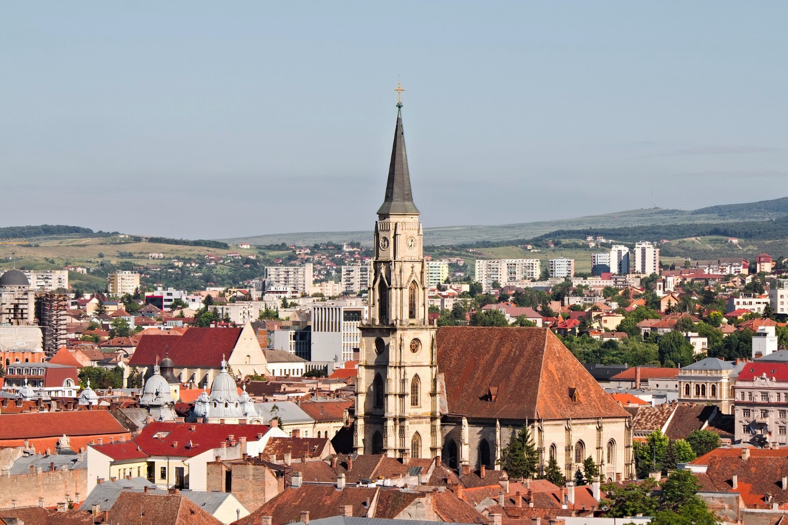 Aerial view of Cluj-Napoca, Romania, with St Michael’s Church spire rising above the terracotta rooftops of the old town