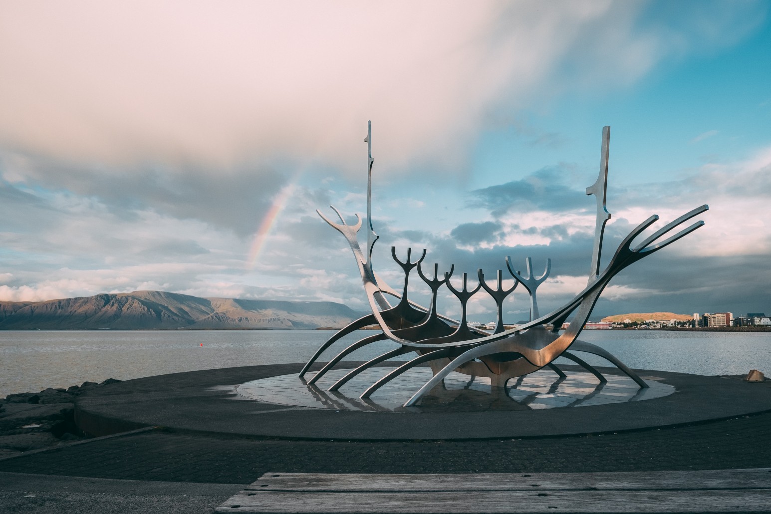 The Sun Voyager steel sculpture on Reykjavík’s waterfront, with a rainbow over the mountains across the bay