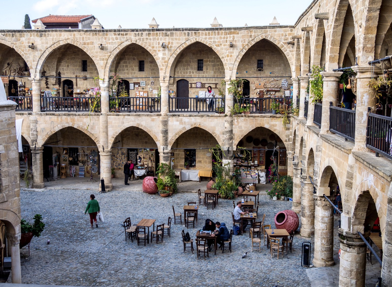 The arched stone courtyard of Büyük Han with cafe tables, in Nicosia, Cyprus