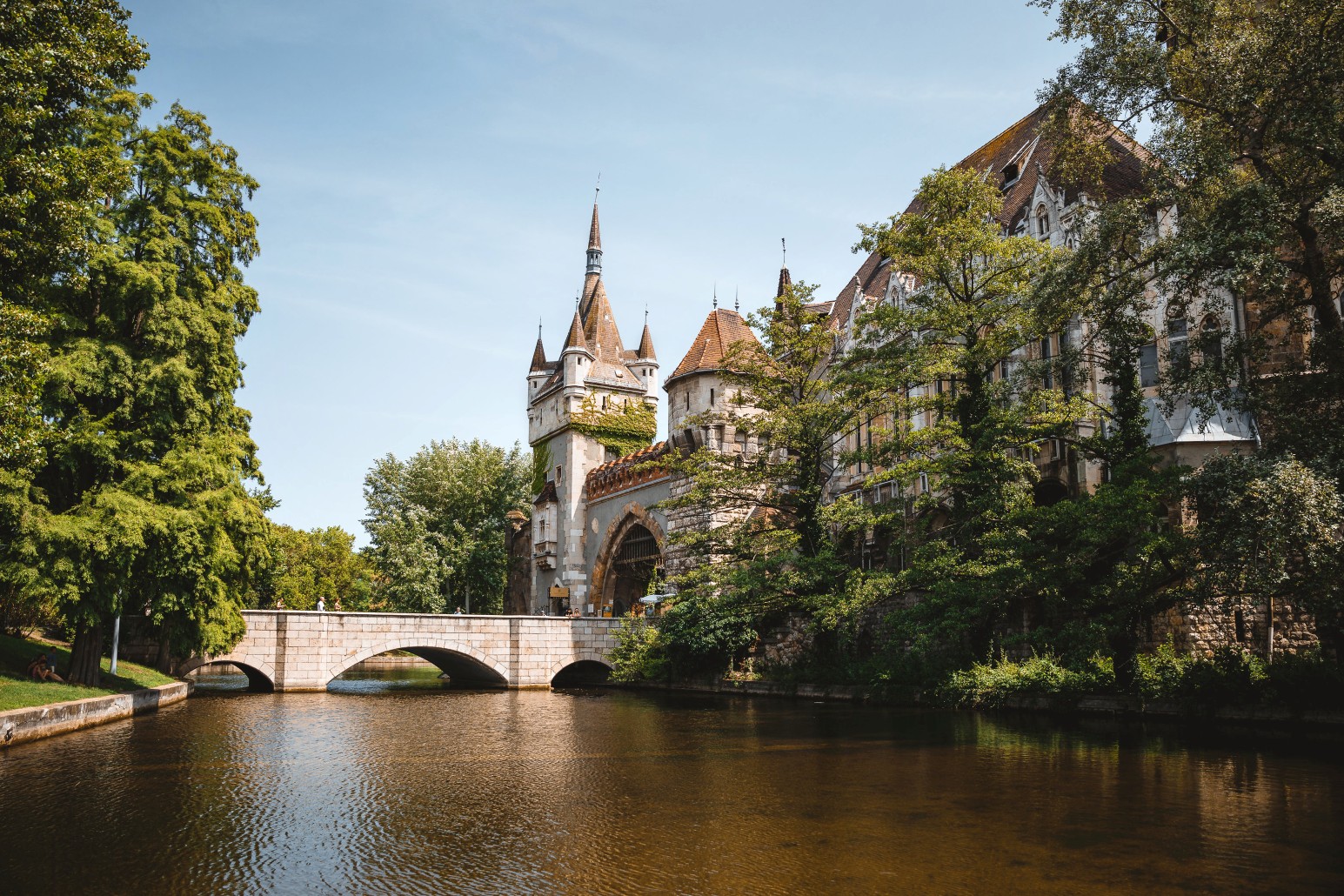 Vajdahunyad Castle in Budapest’s City Park, its turrets rising above a stone bridge crossing the surrounding lake