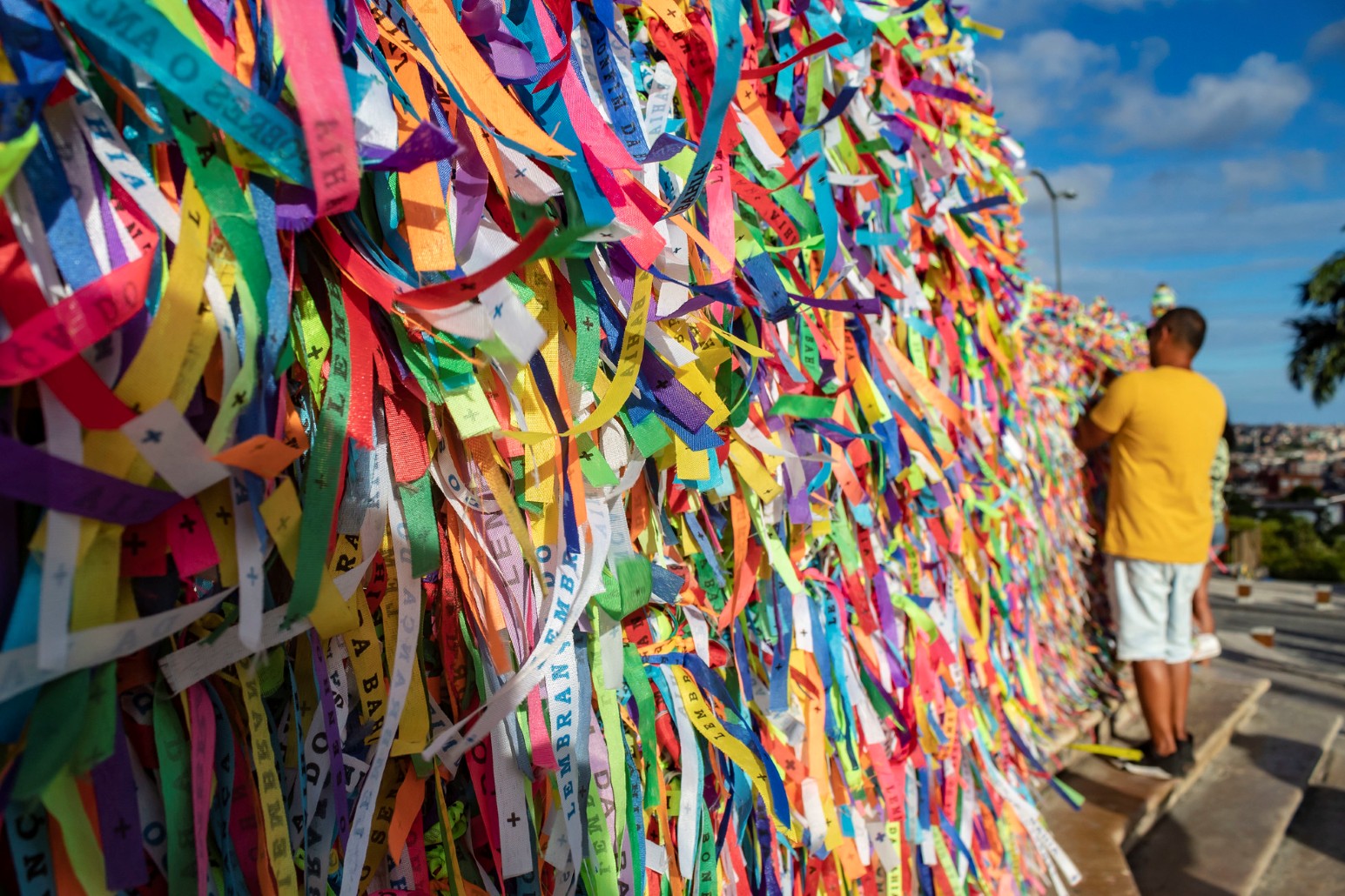 Colourful wish ribbons tied to railings outside the Church of Our Lord of Bonfim in Salvador