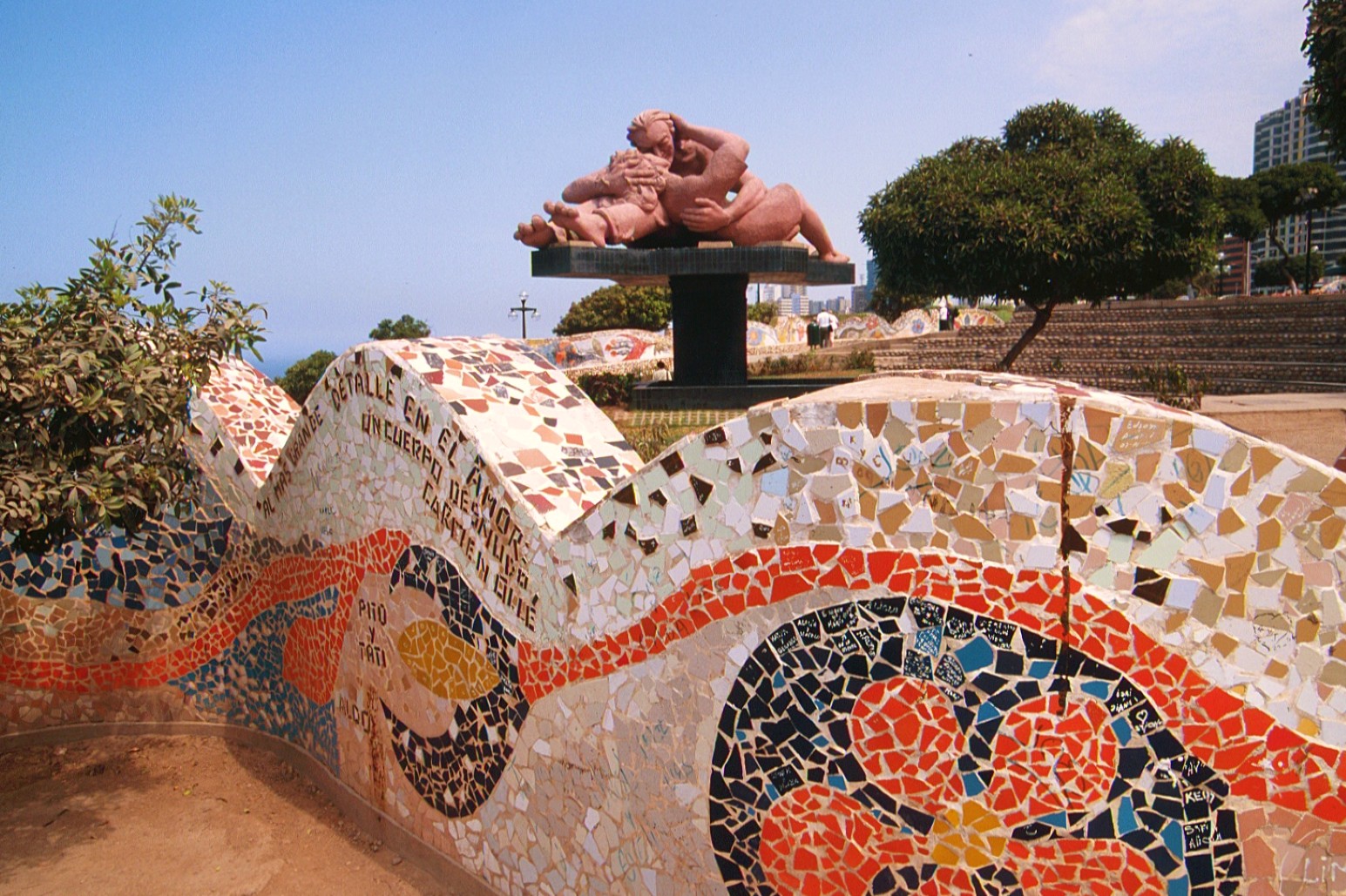 A mosaic-tiled wave sculpture and reclining couple statue in Parque del Amor, overlooking the coastline in Lima