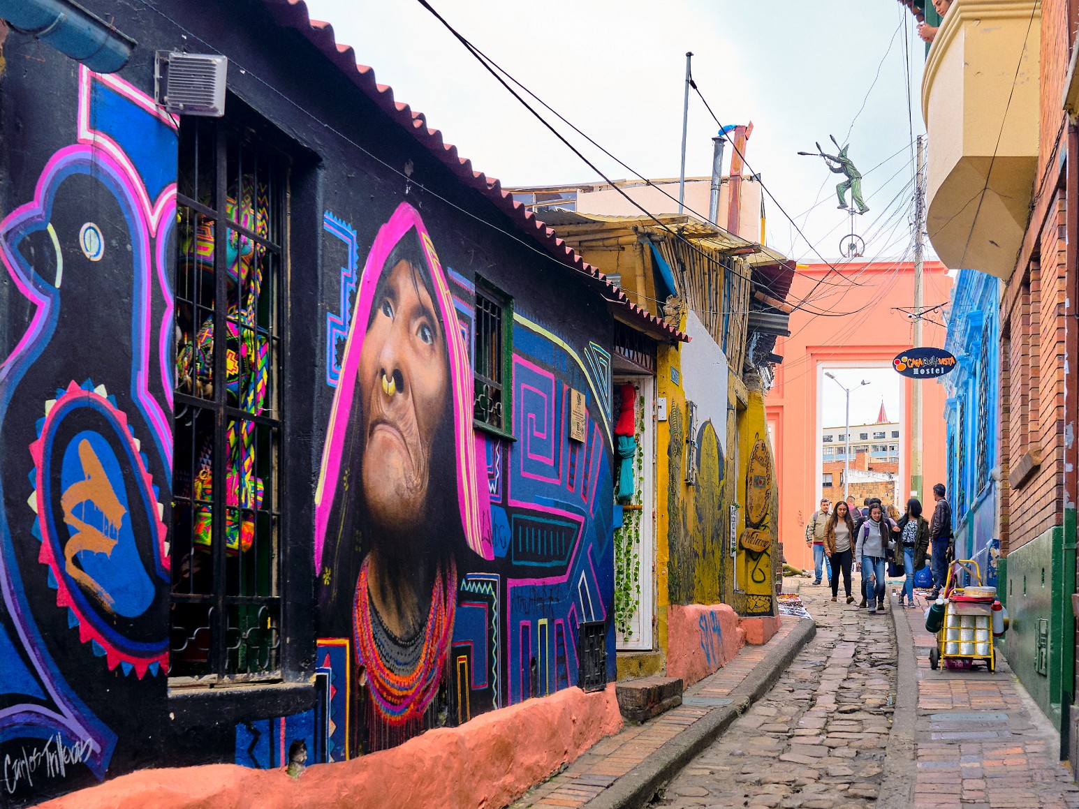 A colourful mural of an indigenous woman on a building along a cobblestone street in Bogotá's La Candelaria neighbourhood
