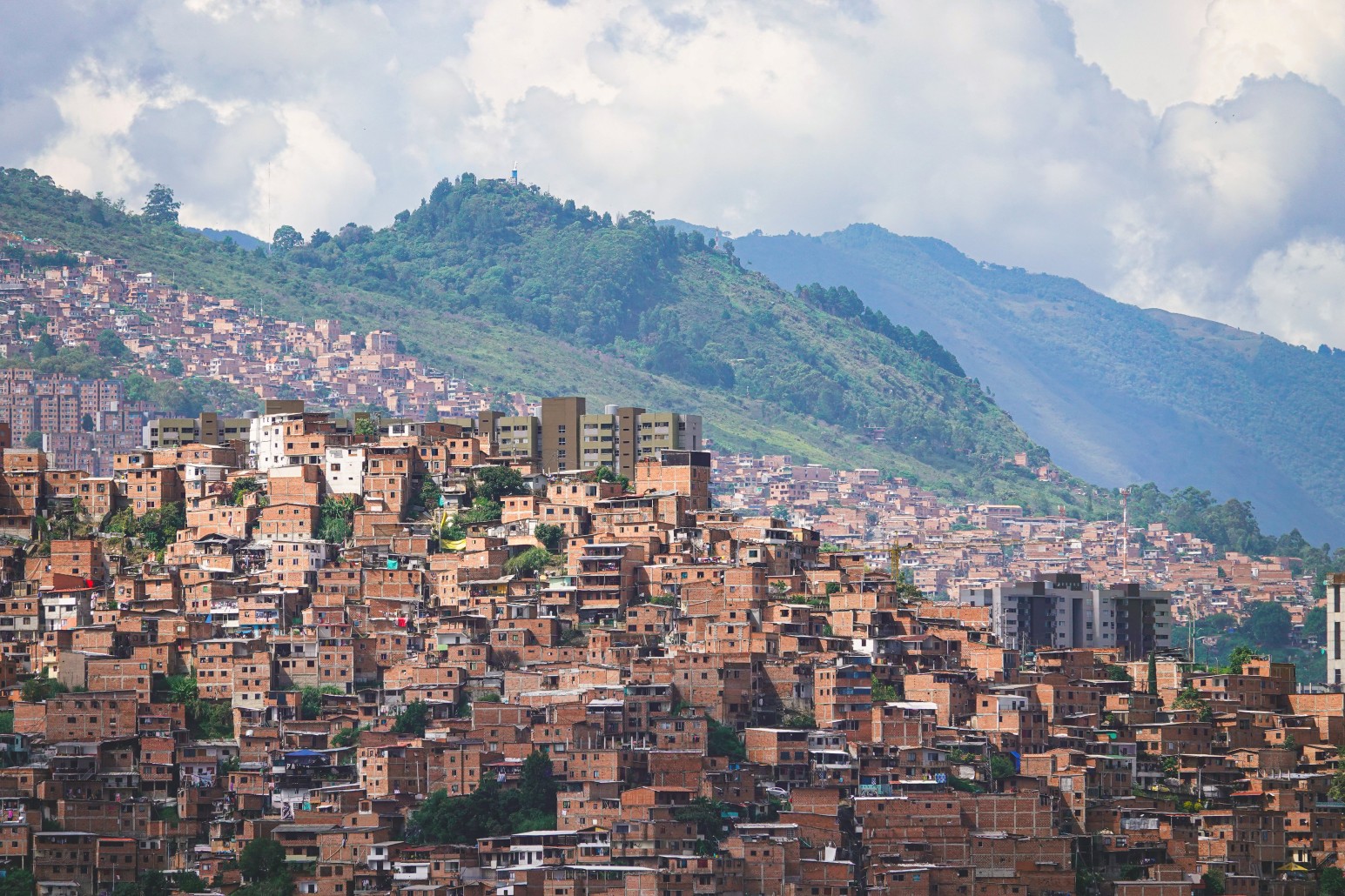 Aerial view of hillside houses climbing up a mountainside in Medellín